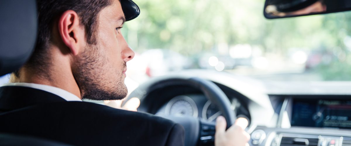 Portrait,Of,A,Handsome,Male,Chauffeur,Riding,Car